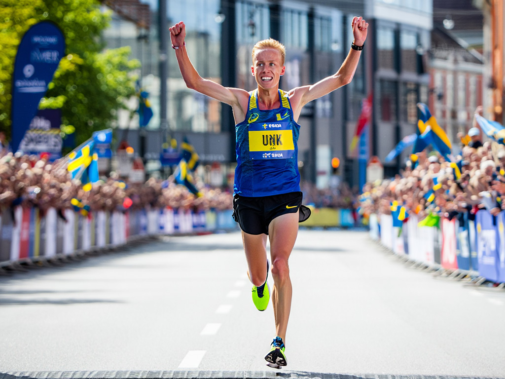 Löpare som korsar mållinjen i ett maraton